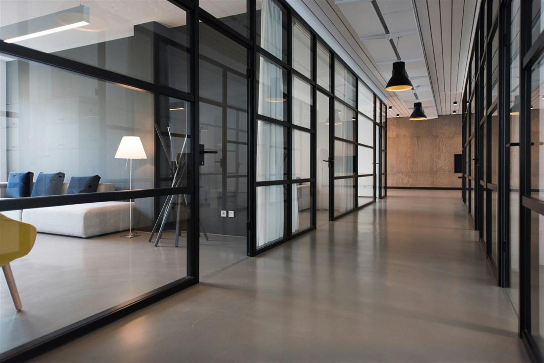 Un couloir de bureaux vitrés au sol impeccable