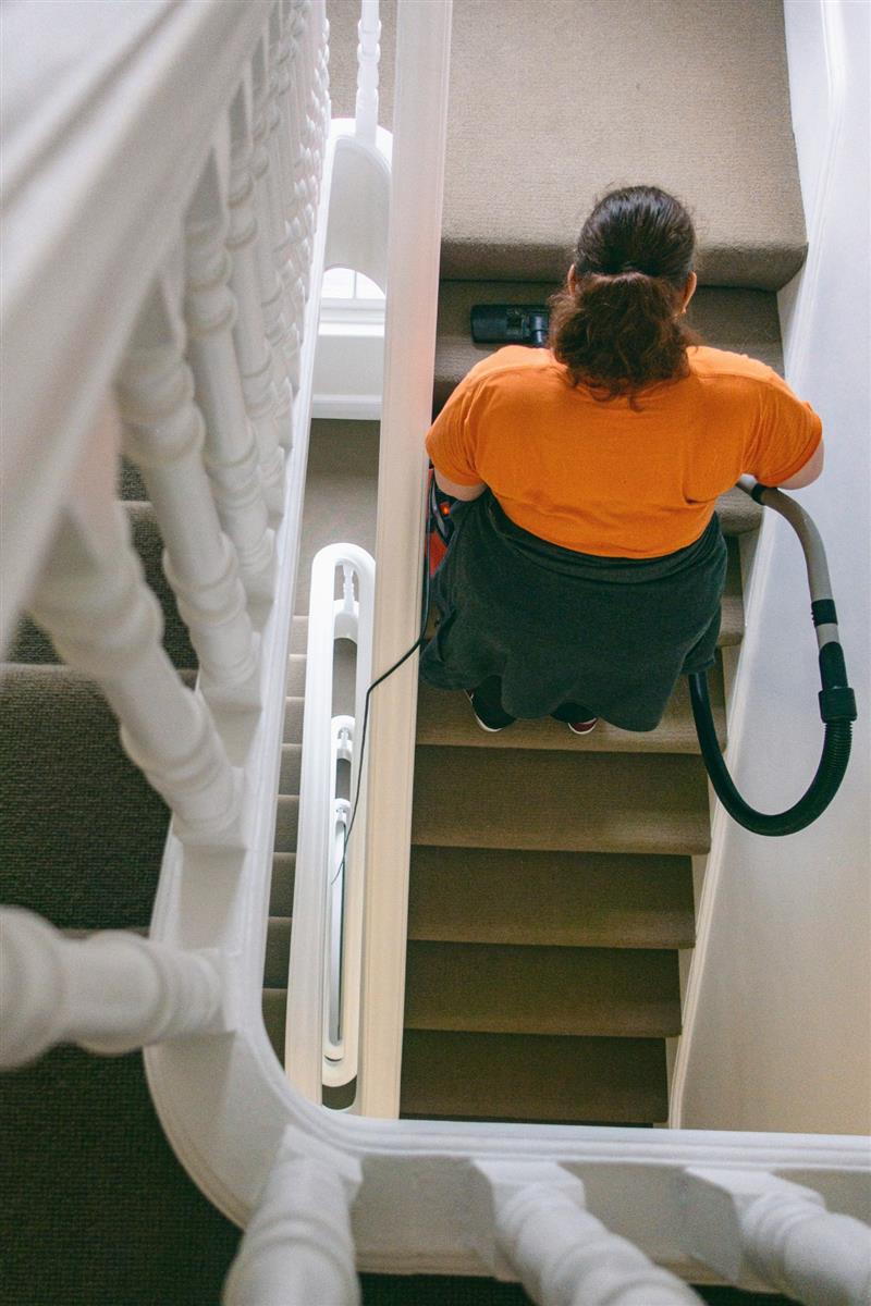 Un agent passe l’aspirateur dans un escalier